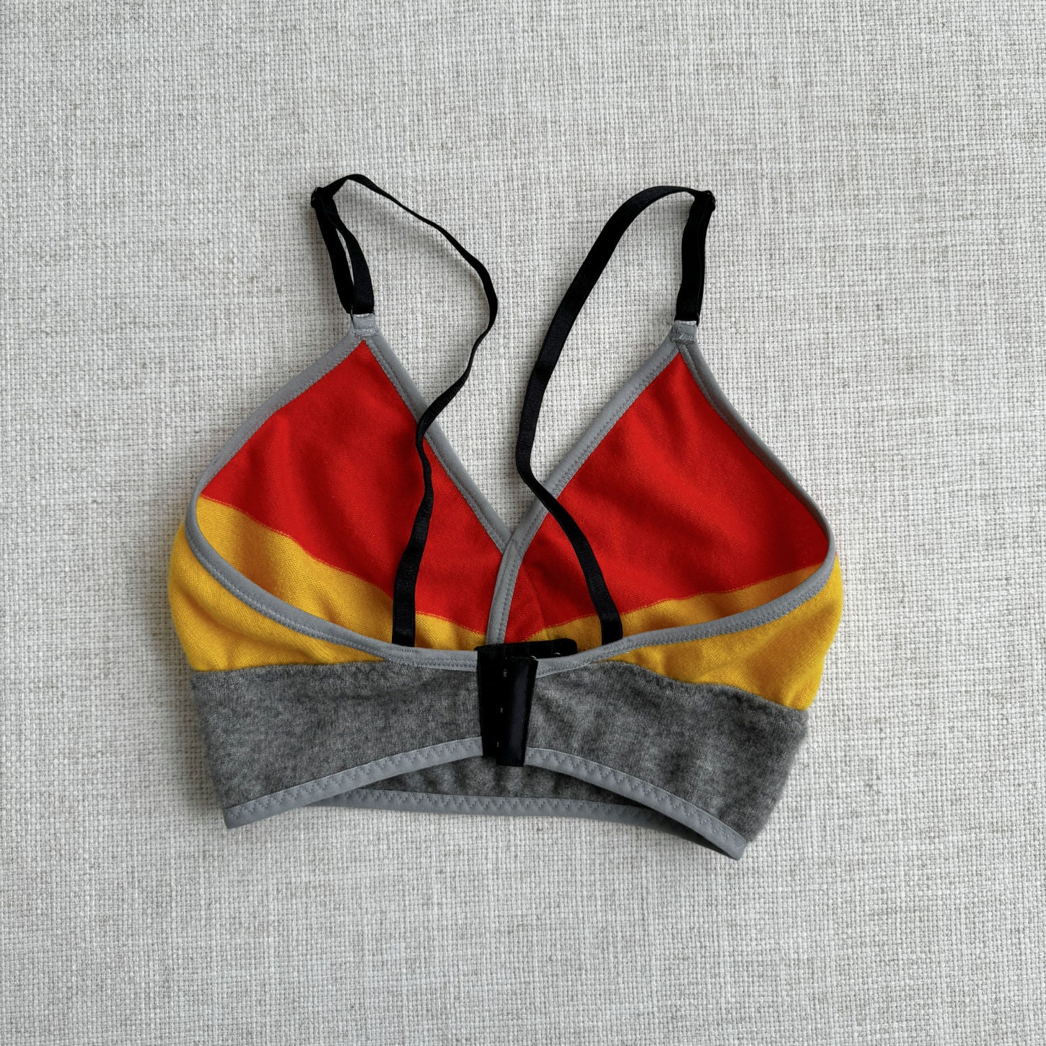 Grey, Orange, and Yellow long cashmere bra top, handmade in Canada by Econica, sumptuous cashmere fabric, bold and bright colors, soft and plush comfort, sustainable and ethical production, contemporary style, artisanal touch, luxurious loungewear, elegant simplicity
