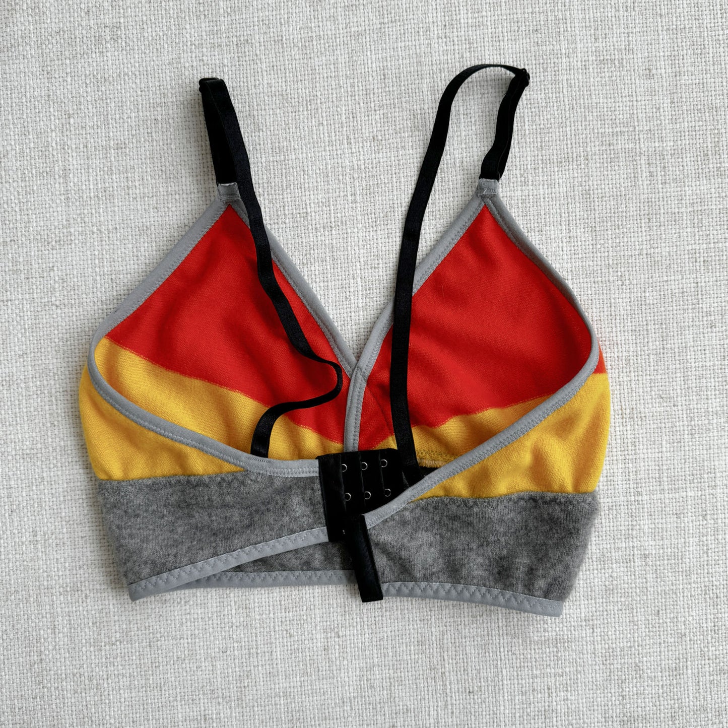 100% cashmere long bra top, vibrant Orange and Yellow with Grey base, made by Econica, Canadian craftsmanship, luxurious feel, eye-catching color combination, handcrafted with care, sustainable luxury, comfortable fit, modern design, natural insulation, artisanal fashion