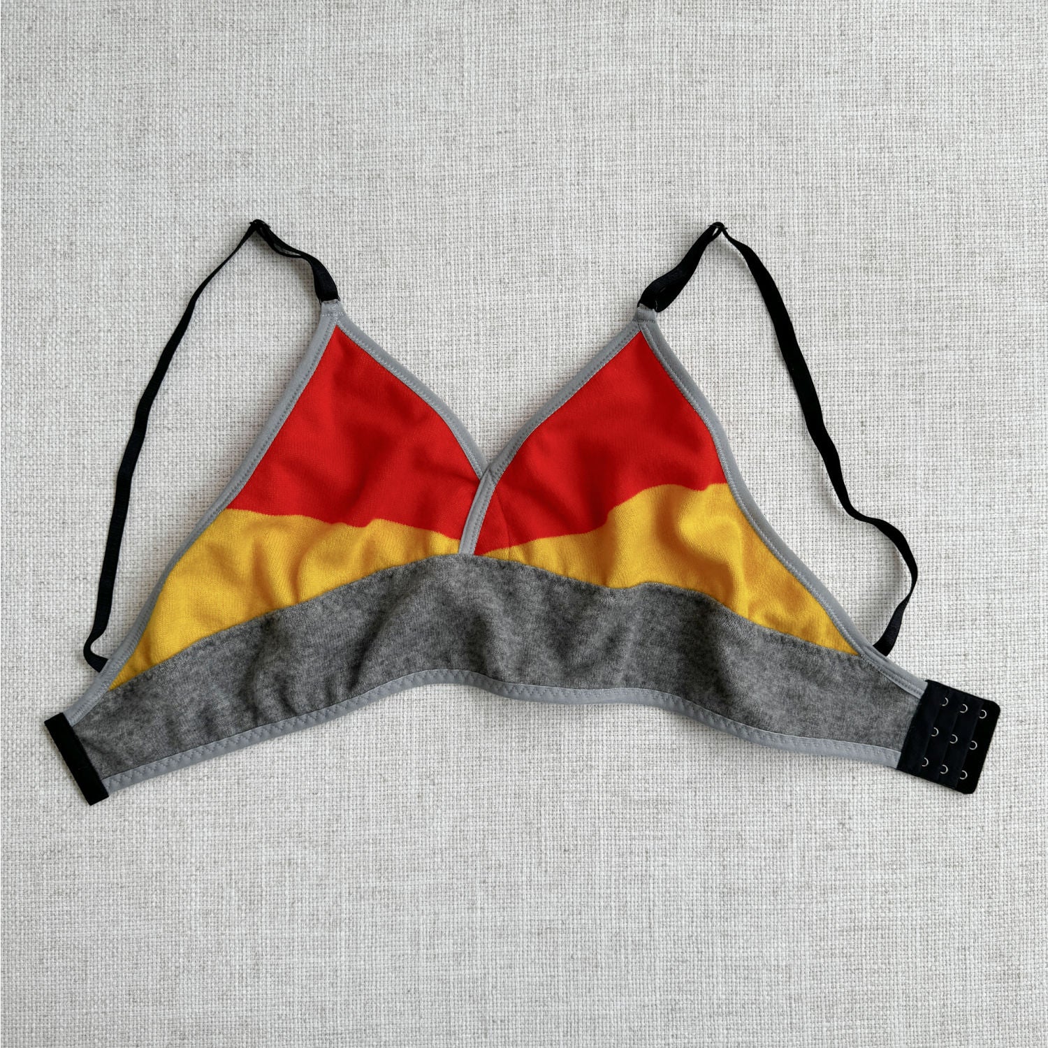 Handmade in Canada by Econica, long cashmere bra top, striking Grey, Orange, and Yellow palette, premium cashmere material, artisanal quality, elegant and cozy, soft-to-the-touch, perfect for layering, sustainable choice, durable construction, stylish loungewear