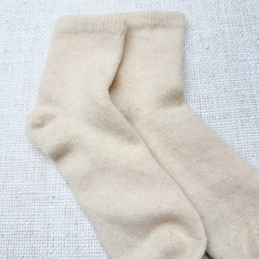 Beige socks on a textured white background