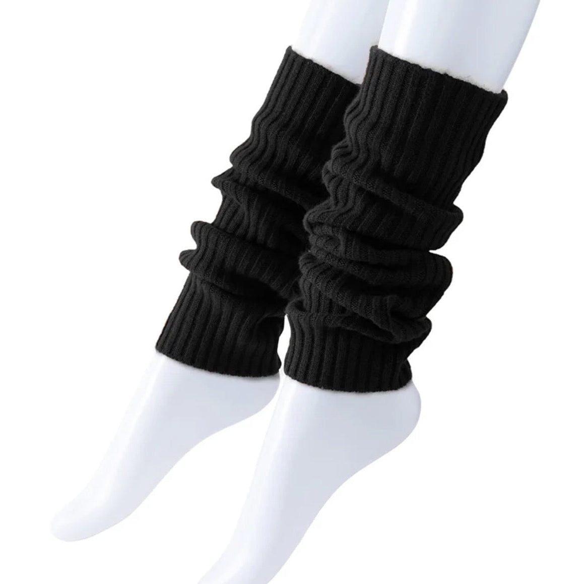 Black knitted leg warmers worn over white socks on a white background