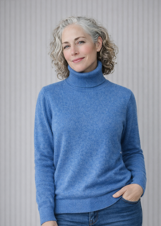 Woman wearing a blue turtleneck sweater against a neutral background