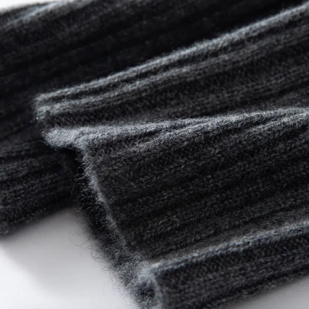 Close-up of dark gray fabric with a ribbed texture on a light background
