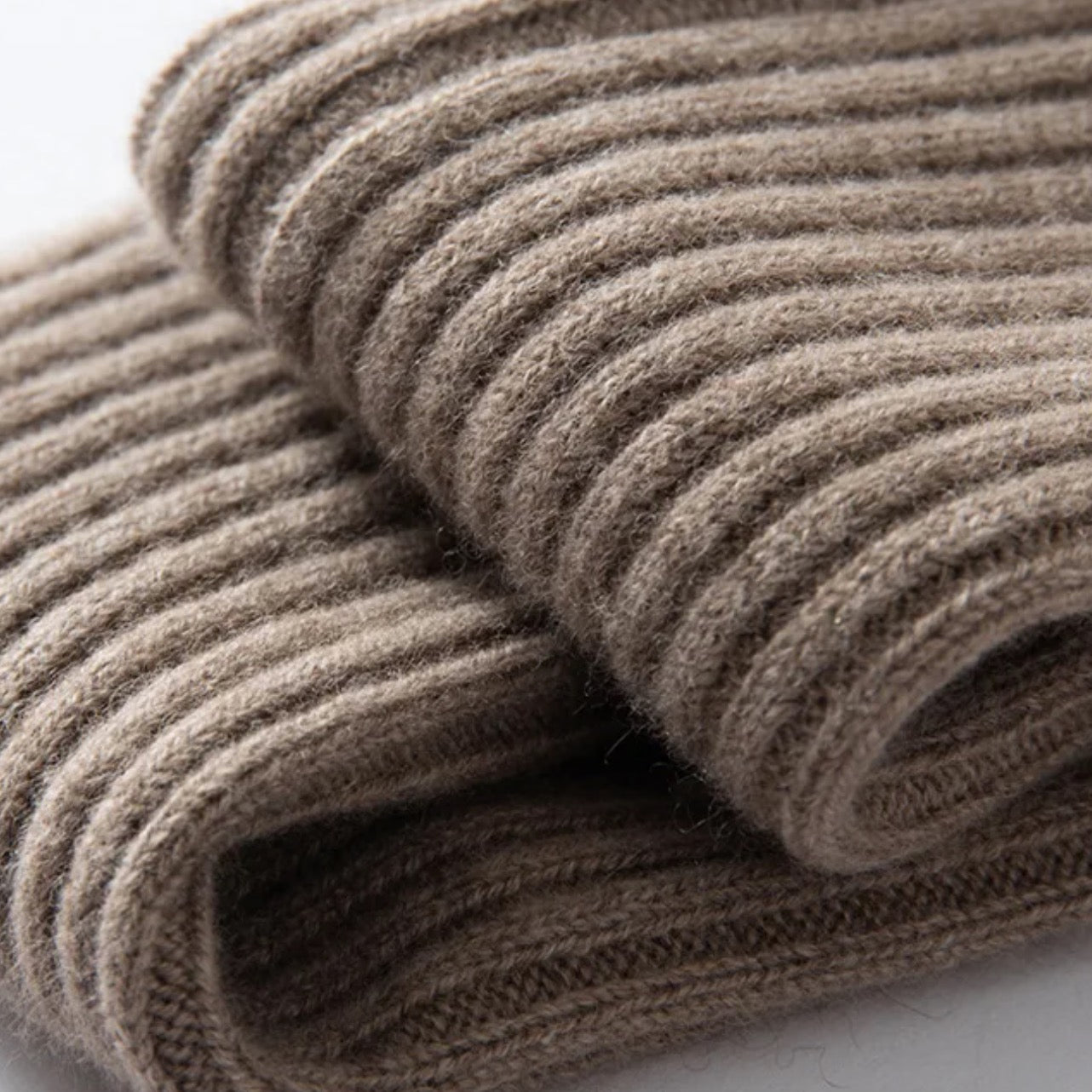 Close-up of a folded brown knitted fabric on a white background
